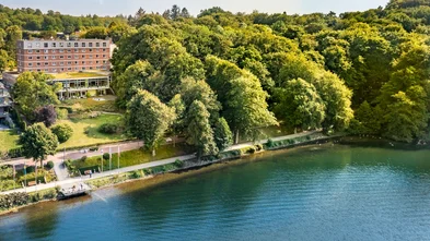 Das Bild zeigt den See und dahinter die Klinik Buchenholm. 